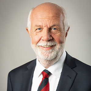 „Porträt eines älteren, sympathisch lächelnden Mannes im Anzug – professionelle Aufnahme für die Team- oder Unternehmensseite.“